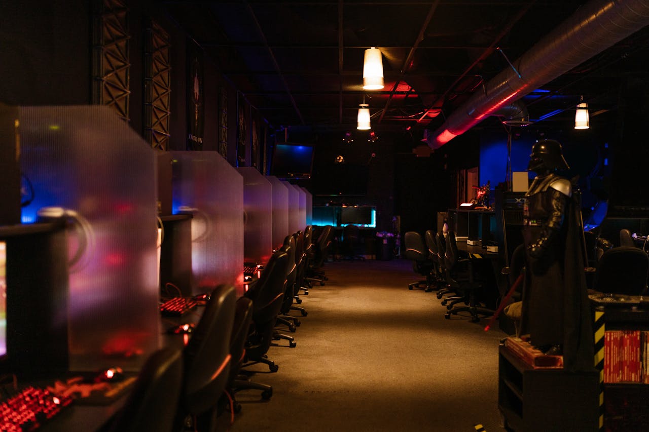 fitness-service-01 A dimly lit gaming arcade with neon lights and computers, creating a futuristic atmosphere.