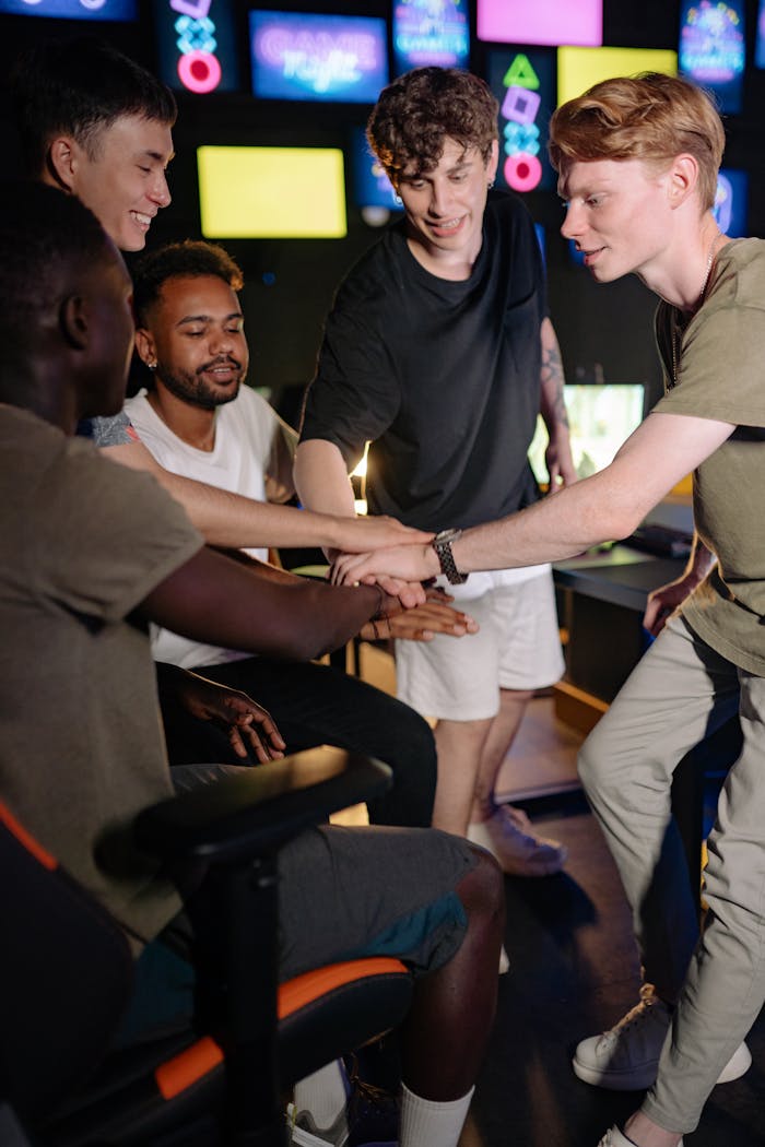 Home A group of diverse young men celebrating teamwork during a gaming session indoors.
